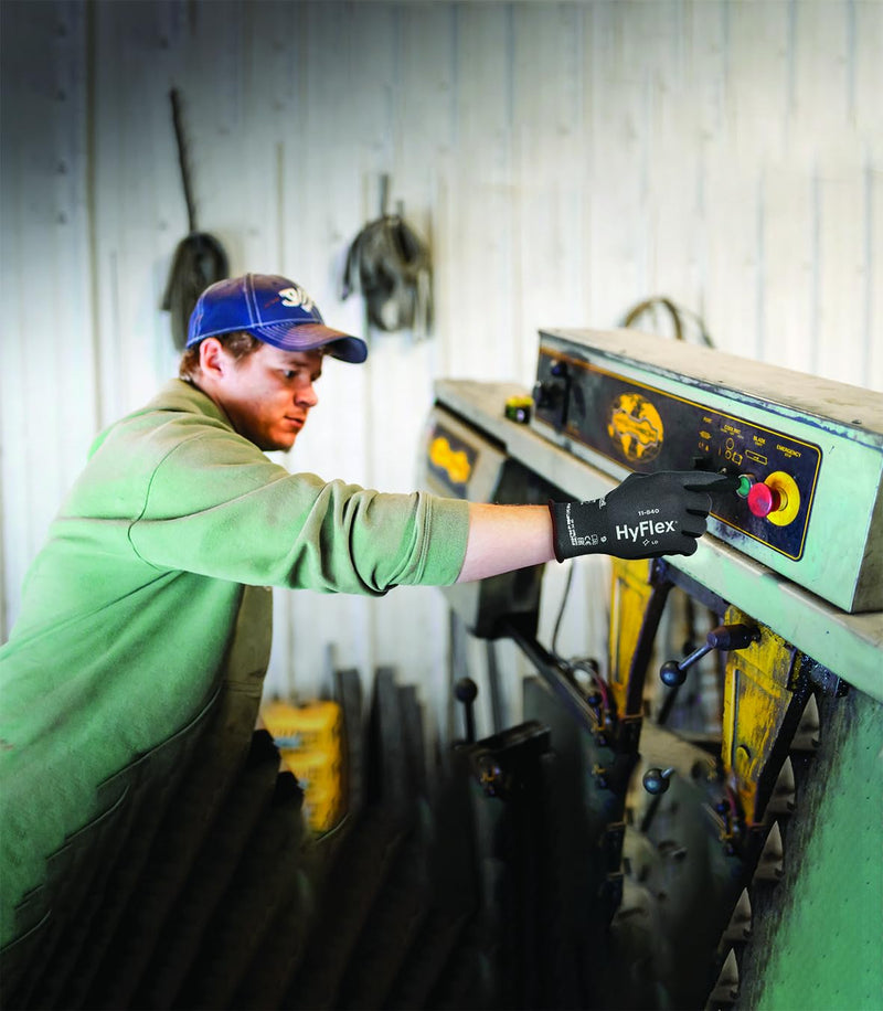 Ansell HyFlex 11-840 gloves worn by a worker handling materials in an industrial environment.