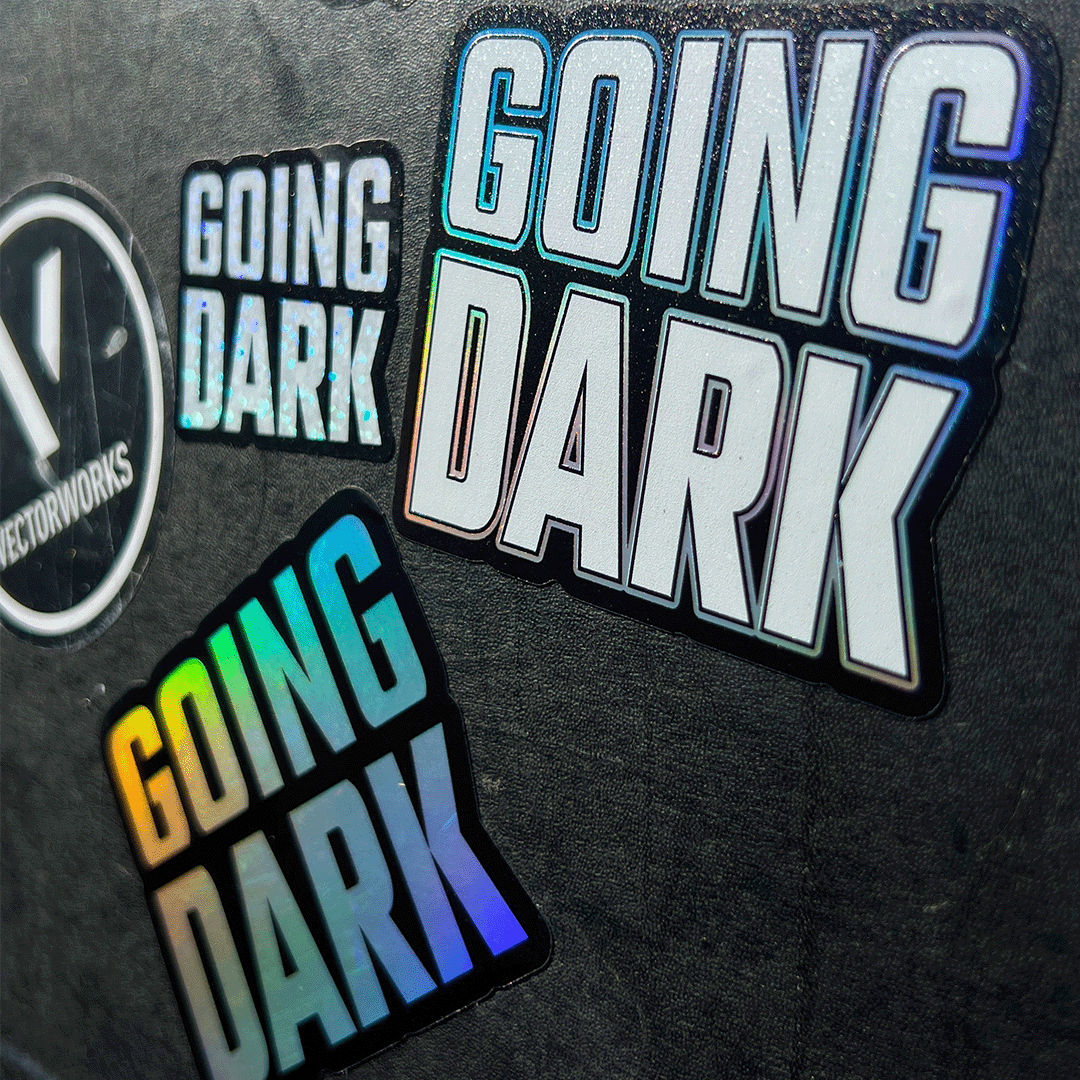 A peli case featuring the Going Dark Special Edition 7-Piece Sticker Set. The set includes a variety of unique finishes, featuring holographic, mirror, and glitter designs that catch the light in all the right ways, creating a dynamic, eye-catching effect. The stickers are displayed on the lid of the peli, with bold, edgy graphics, including abstract patterns, logos, and stylised text, adding a custom, artistic flair.