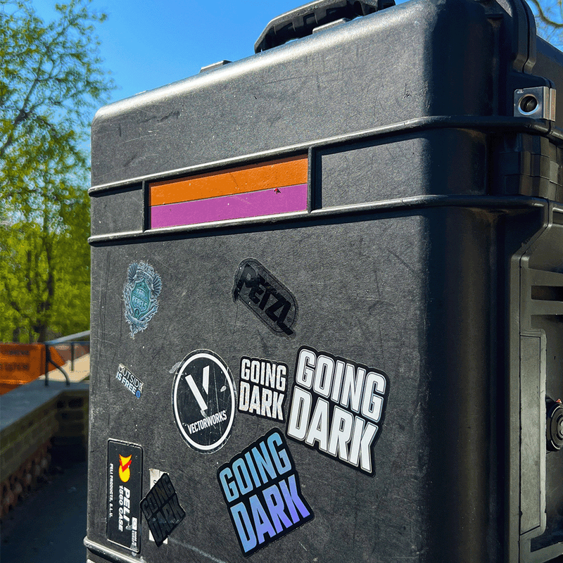 A peli case featuring the Going Dark Special Edition 7-Piece Sticker Set. The set includes a variety of unique finishes, featuring holographic, mirror, and glitter designs that catch the light in all the right ways, creating a dynamic, eye-catching effect. The stickers are displayed on the lid of the peli, with bold, edgy graphics, including abstract patterns, logos, and stylised text, adding a custom, artistic flair.