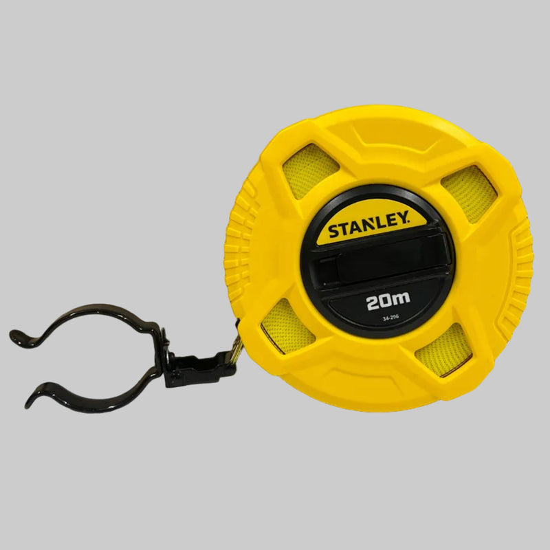 A yellow and black Stanley digital tape measure with a black mounting clip, shown against a brown cardboard background.